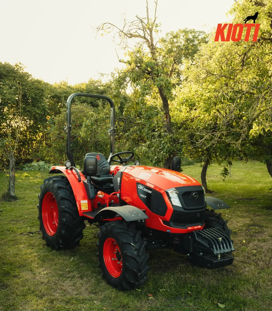 Roter KIOTI-Kompakttraktor auf einer Obstwiese